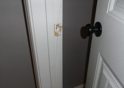 Secure door framing, solidify broken wood, repaint and replace latch