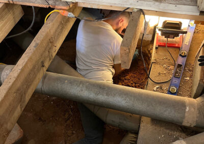 Handyman Mark employee, based in Forsyth County, North Carolina, works in a very tight crawl space to repair rotting floor joists