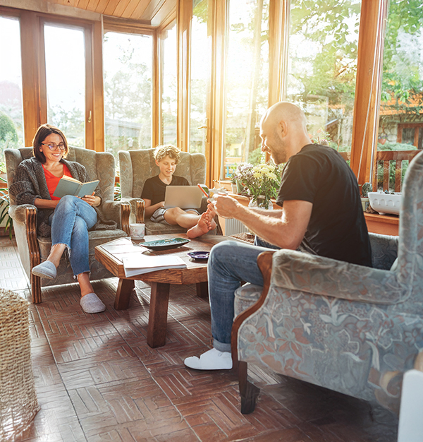 screen porch converted into a sunroom where family lounges