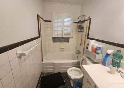 old 1950s bathroom with black and white tile and linoleum flooring