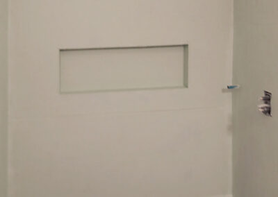 bathroom stall with new drywall, ready for tile installation